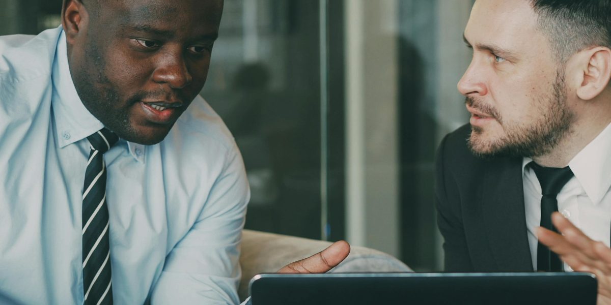 Dwaj partnerzy biznesowi omawiający strategiczne decyzje dotyczące formy prawnej firmy.